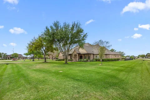 a front view of a house with a yard and trees