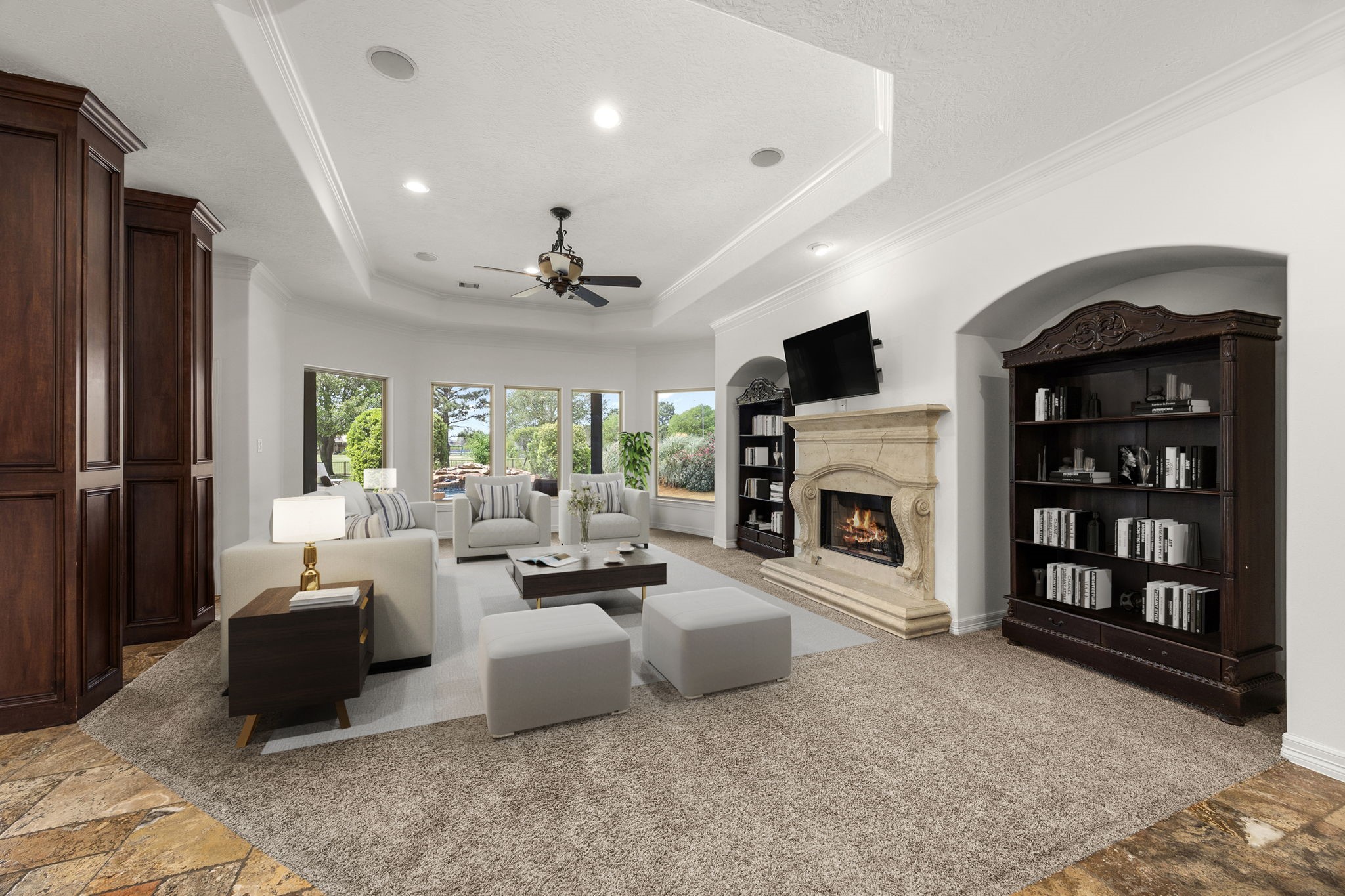 4611 Oasis Point Katy, TX 77493 - Photo 5 of 41 Wood-wrapped columns and neutral carpet define the space of the living area, creating a dedicated space for relaxing with friends and family with impressive views of your backyard oasis and the lake beyond. A gaslog fireplace with stone surround is ready and waiting for when temps drop again. Wired for sound, this living room is ready for formal entertaining or casual movie nights. Bookshelves are not attached, meaning you can personalize the recessed niches to fit your entertainment equipment or artwork.