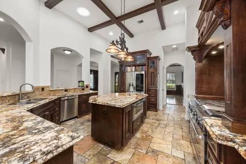 a large kitchen with kitchen island a stove a sink dishwasher and wooden cabinets
