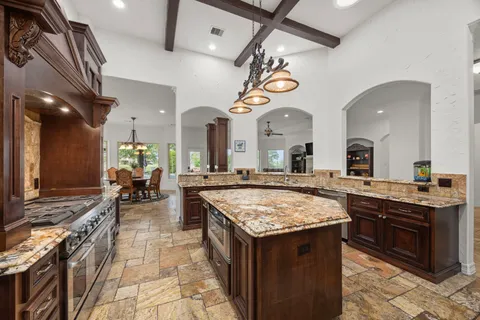 a kitchen with a stove a counter space a sink and cabinets