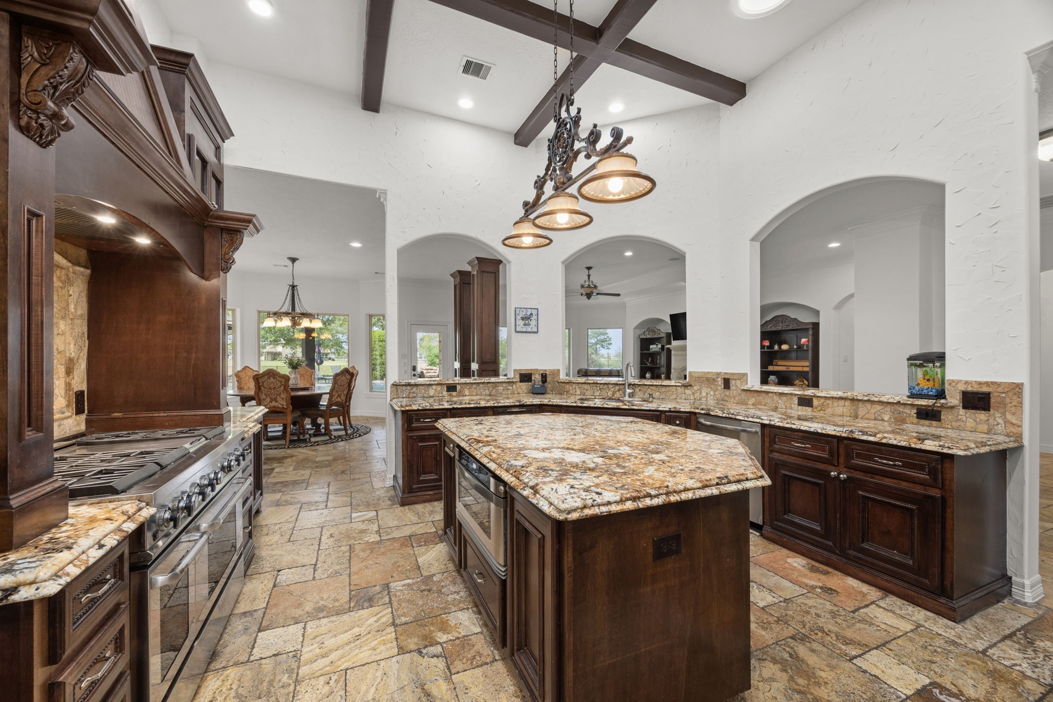 4611 Oasis Point Katy, TX 77493 - Photo 10 of 41 Enjoy abundant countertop space for meal prep and serving, an undermount microwave in the island, and the perfect balance of modern convenience with classic architecture. This kitchen is ready for the chef in the household. The upgraded gas range with dual ovens. Located in the center of the home, this kitchen is a true hub, with views from the front of the home all the way to the backyard and beyond.