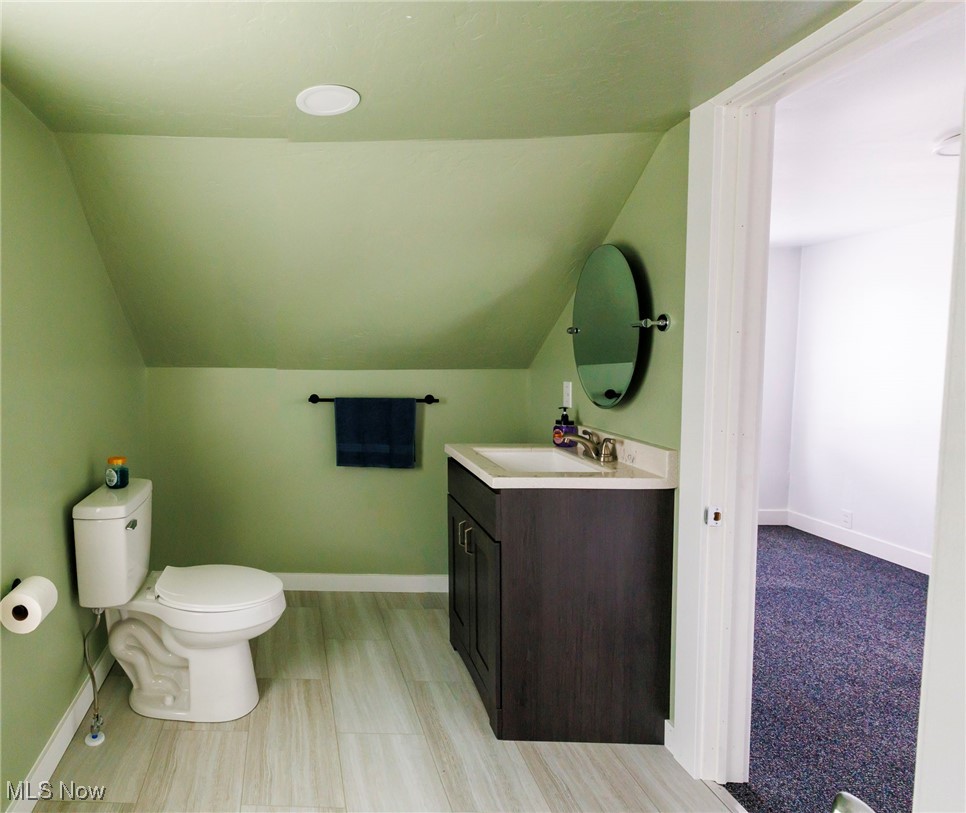 13239 Navarre Road Southwest Beach City, OH 44608 - Photo 30 of 48 Bathroom featuring vaulted ceiling, toilet, baseboards, and vanity