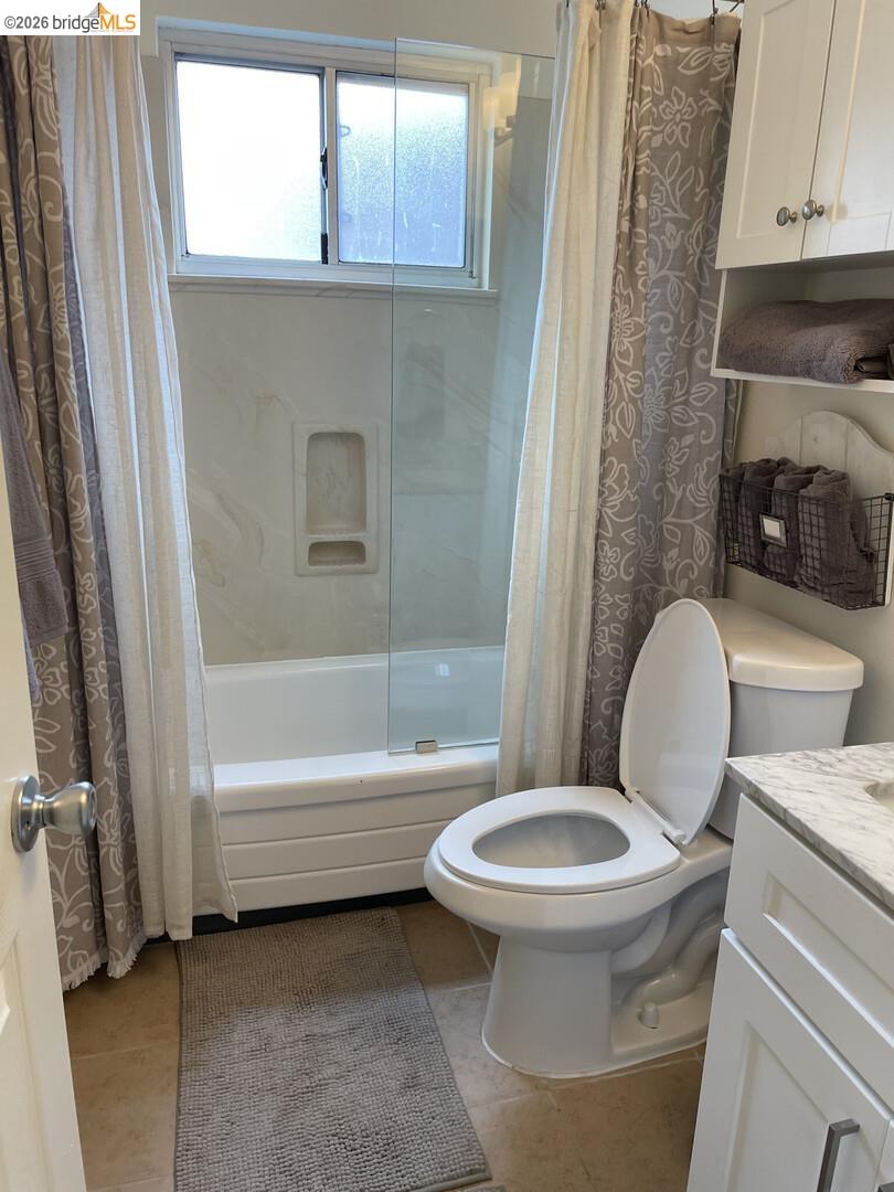 1728 Seventh Street, Unit F Berkeley, CA 94710 - Photo 6 of 6 bathroom with shower / bathtub combination with curtain, vanity, and light tile patterned floors