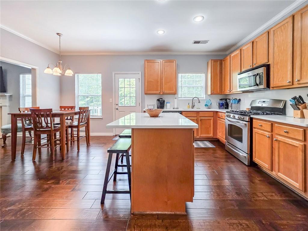 43 Ivy Mist Lane Acworth, GA 30101 - Photo 6 of 58 a kitchen with stainless steel appliances granite countertop a stove a sink a microwave a dining table and chairs