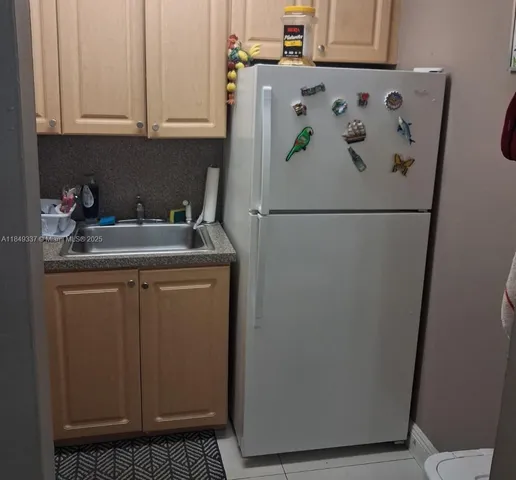a white refrigerator freezer sitting inside of a kitchen