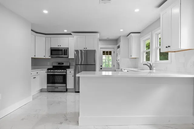 a kitchen with kitchen island a sink stainless steel appliances and cabinets