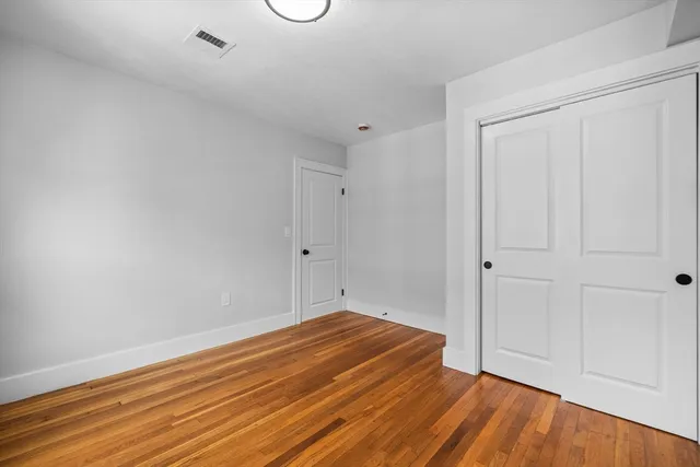 a view of a room with wooden floor