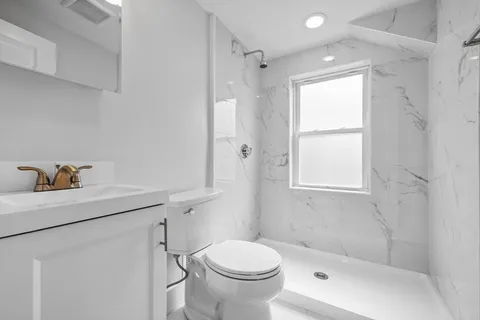 a bathroom with a sink toilet and shower
