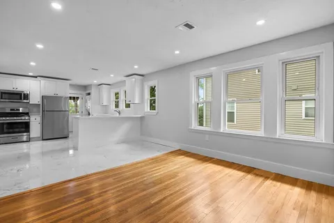 a view of kitchen with wooden floor and electronic appliances