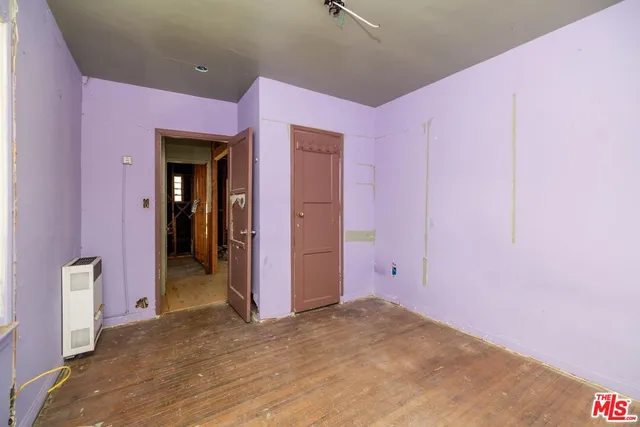 an empty room with a window and wooden floor