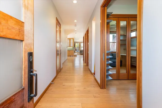 a view of a hallway with wooden floor and living room