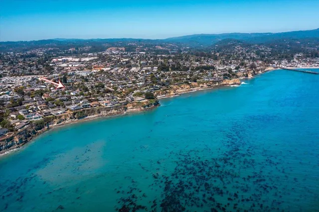 an aerial view of residential houses with outdoor space and trees