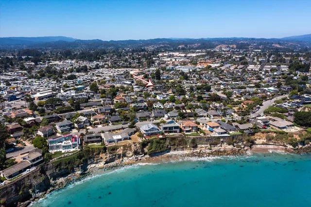 an aerial view of residential houses with outdoor space and trees