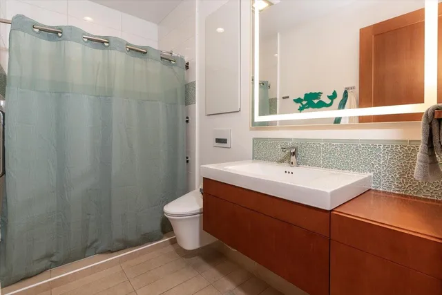 a bathroom with a sink toilet a mirror and shower