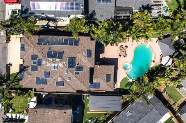 an aerial view of a house with a yard and large trees
