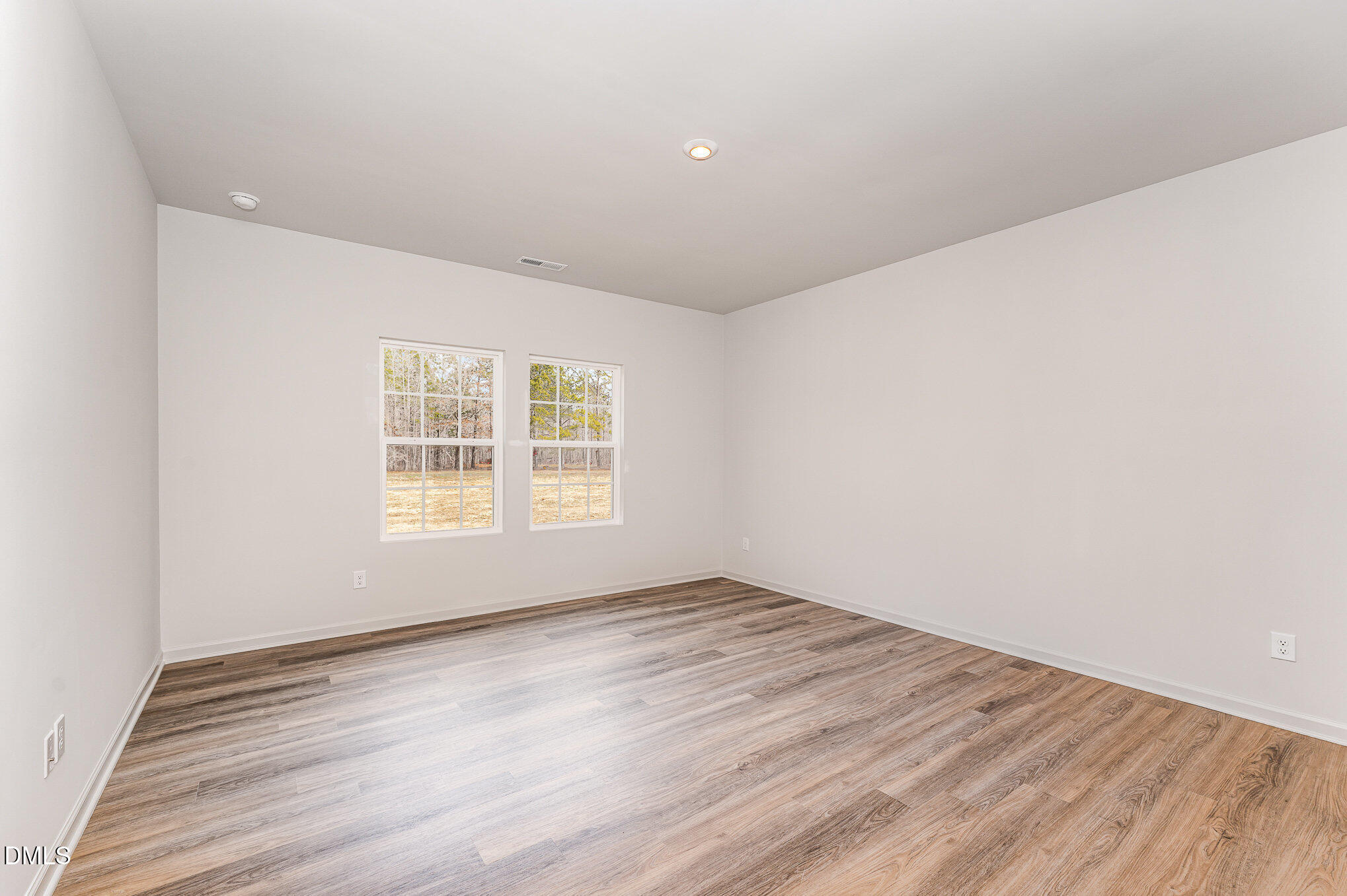 146 Starlet Ridge Way Clayton, NC 27520 - Photo 6 of 18 an empty room with wooden floor and windows