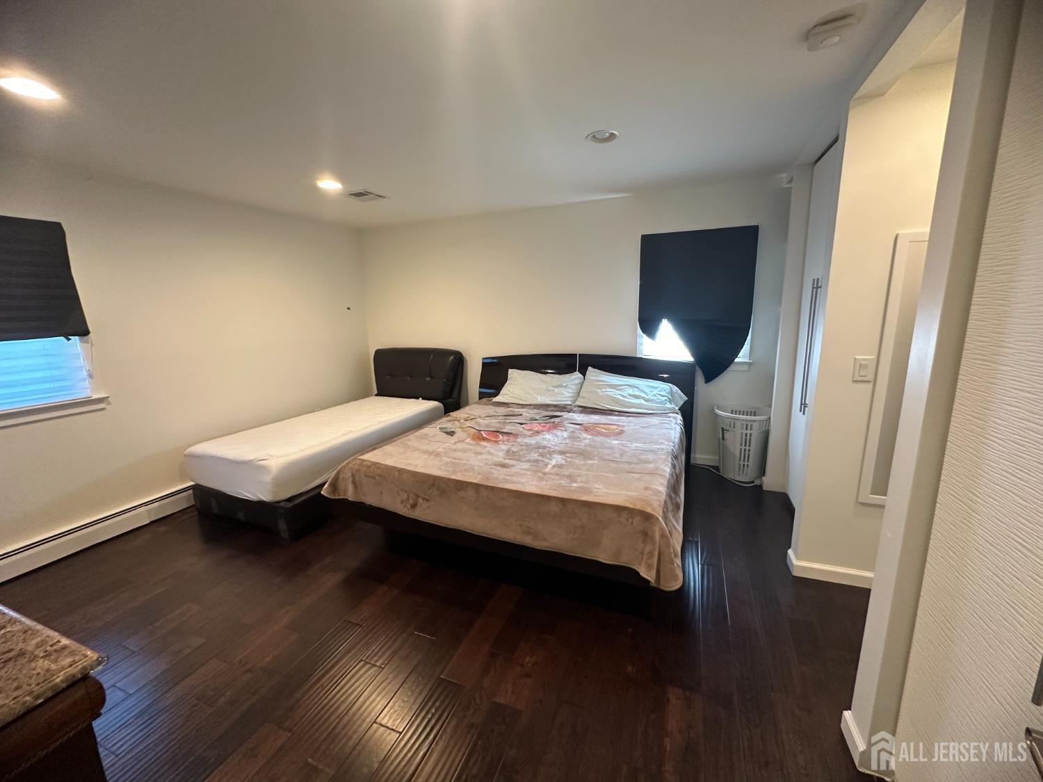 9 Holly Road Iselin, NJ 08830 - Photo 14 of 31 a bedroom with a bed and a wooden floor