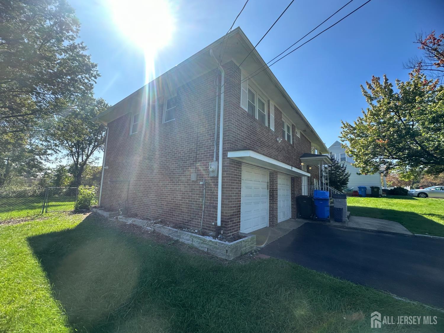 9 Holly Road Iselin, NJ 08830 - Photo 2 of 31 a backyard of a house with trees and wooden fence