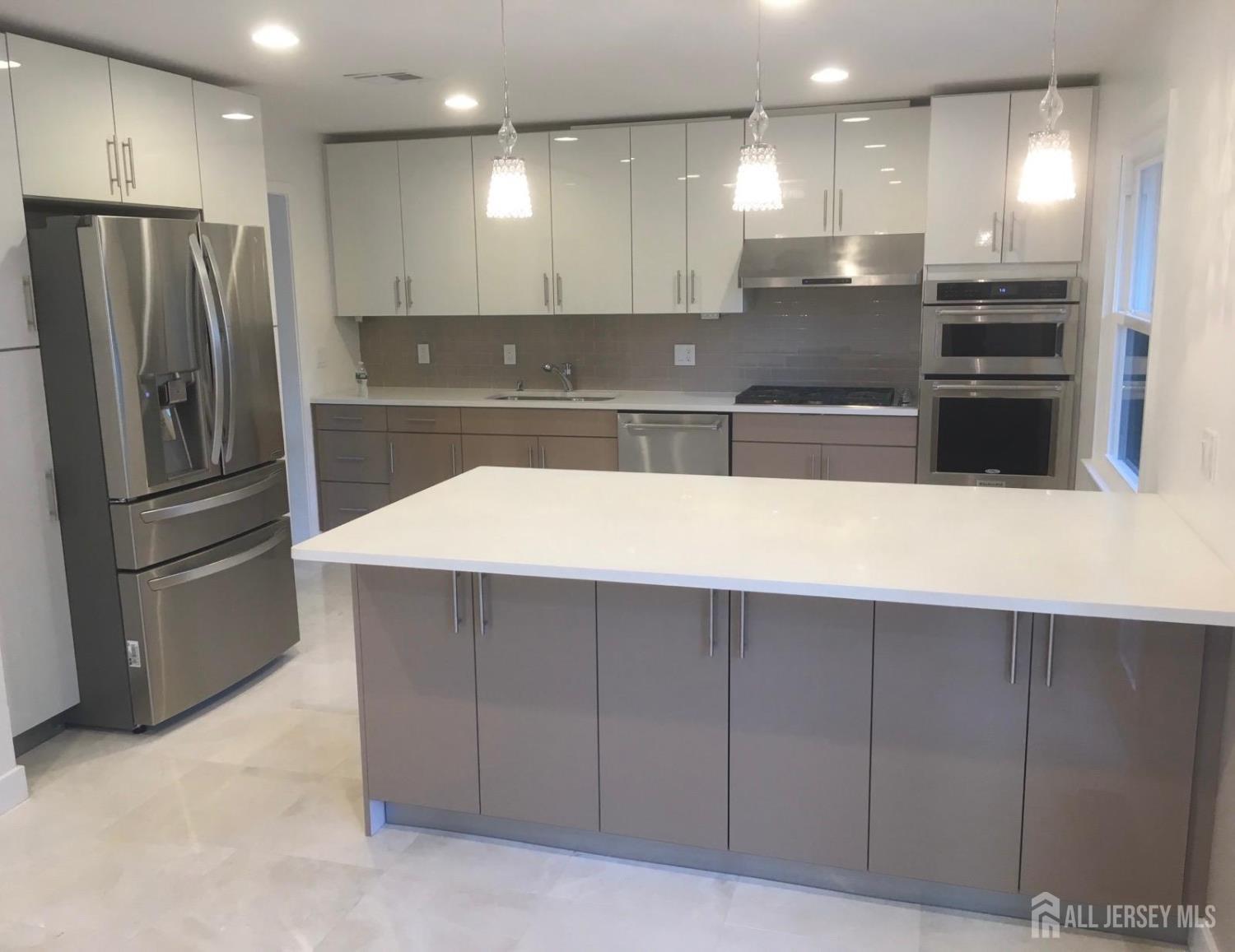 9 Holly Road Iselin, NJ 08830 - Photo 22 of 31 a large kitchen with a large counter top stainless steel appliances and cabinets
