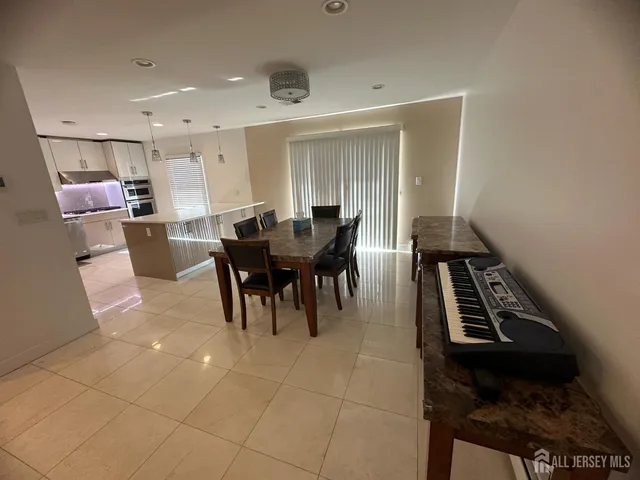 a large kitchen with stainless steel appliances kitchen island granite countertop a refrigerator a sink and a stove