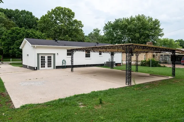 a view of a house with backyard and trees