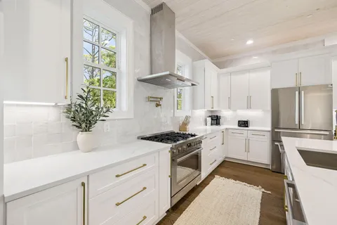 a kitchen with stainless steel appliances kitchen island granite countertop a table chairs and a refrigerator