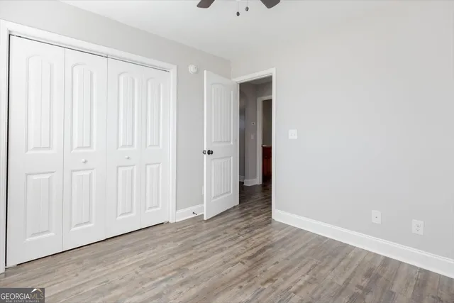 a front view of a house with a yard and a large tree