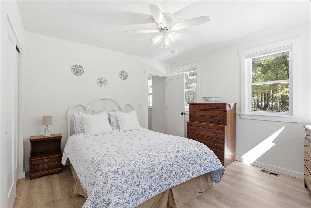 7 Crane Landing Road Wareham, MA 02571 - Photo 15 of 40 a bedroom with a large bed and a chandelier