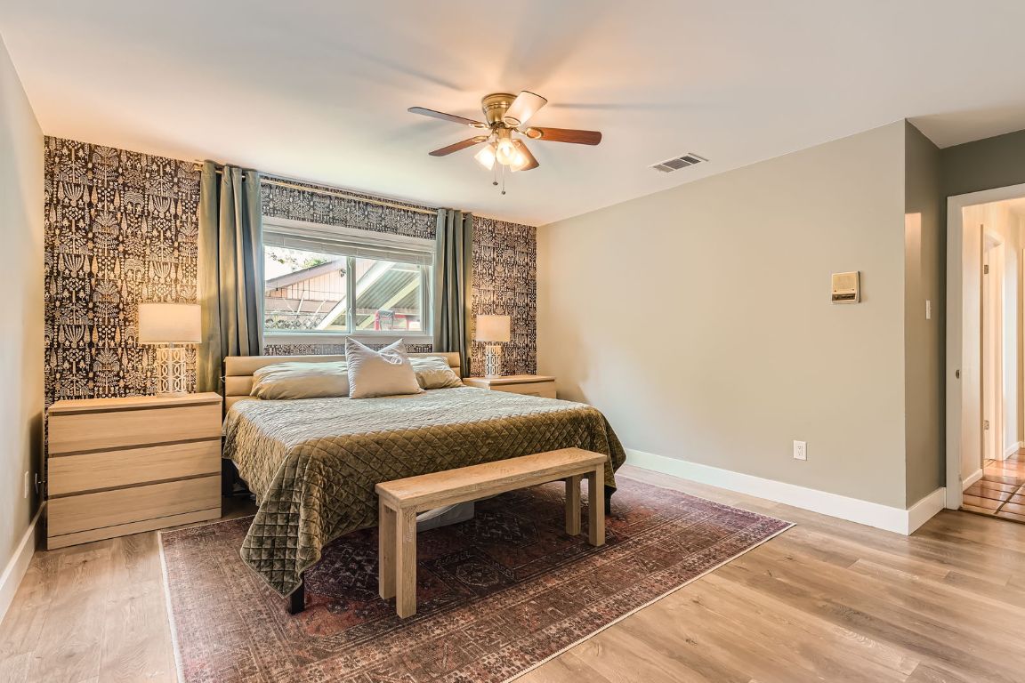 13223 Broadmeade Avenue Austin, TX 78729 - Photo 16 of 39 a bedroom with a bed and a large window with outer view