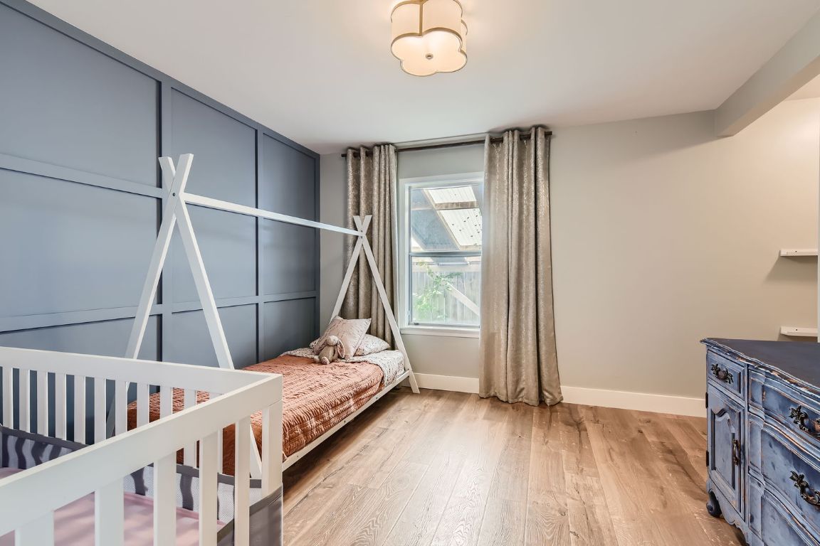 13223 Broadmeade Avenue Austin, TX 78729 - Photo 21 of 39 a bedroom with a bed and wooden floor