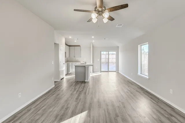a view of a kitchen with a fridge wooden floor and a window