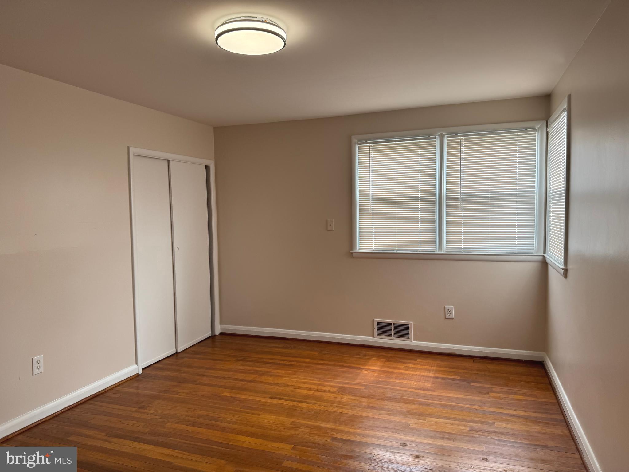 609 Wallerson Road Baltimore, MD 21228 - Photo 3 of 15 an empty room with wooden floor and windows