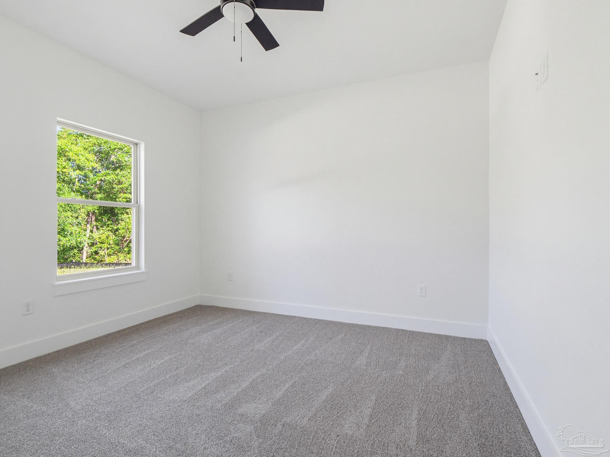 5724 Riviera Drive Milton, FL 32583 - Photo 5 of 52 an empty room with a window and a ceiling fan