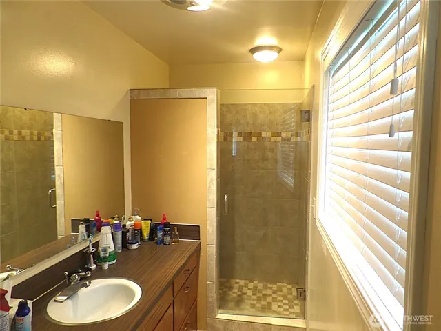 a bathroom with a sink shower and a mirror
