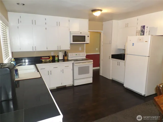 a kitchen with a sink a refrigerator a microwave and cabinets