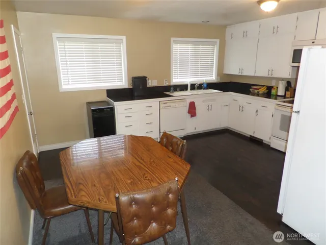 a kitchen with a sink a stove a refrigerator a dining table and chairs