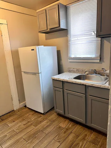 a room with a refrigerator and a dresser