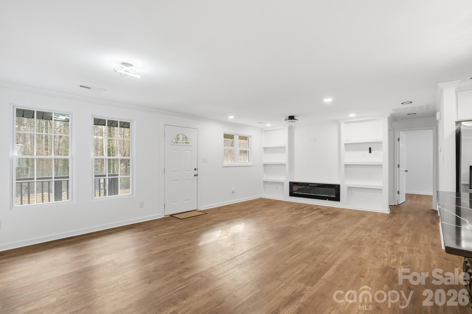 704 West Border Street Dallas, NC 28034 - Photo 19 of 48 a view of an empty room with wooden floor and kitchen