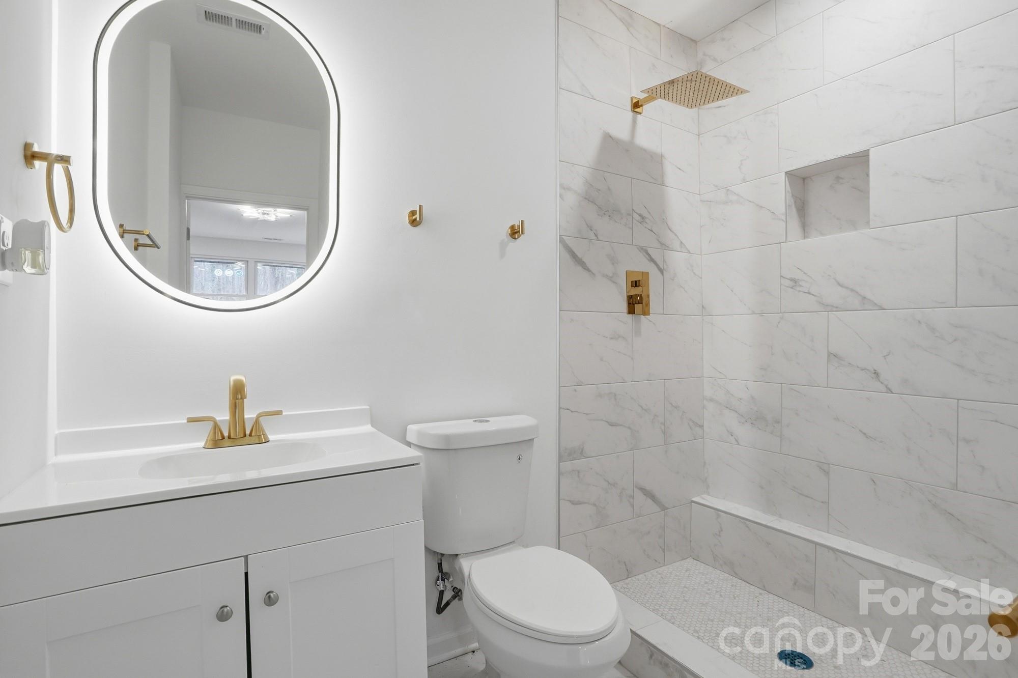 704 West Border Street Dallas, NC 28034 - Photo 5 of 48 a bathroom with a toilet a sink and a mirror