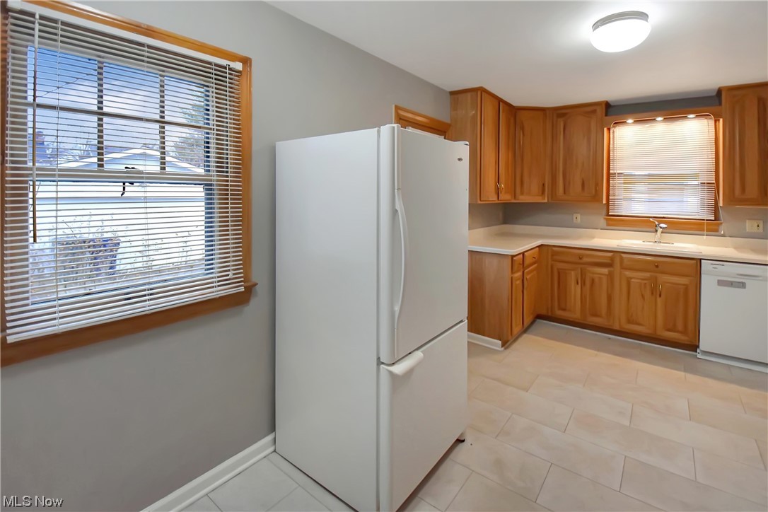1068 Rushleigh Road Cleveland Heights, OH 44121 - Photo 9 of 22 Kitchen with sink, white appliances, and light tile floors