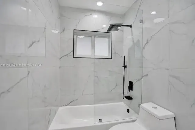 a bathroom with a shower a toilet and sink
