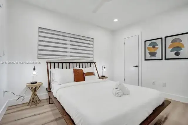 a bedroom with a bed and painting on the wall