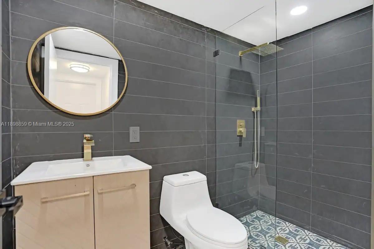 2100 Southwest 28th Way Fort Lauderdale, FL 33312 - Photo 31 of 40 a bathroom with a toilet sink vanity and mirror