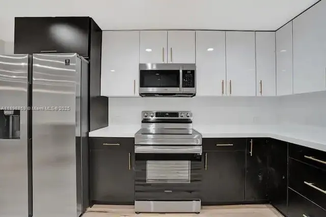 a kitchen with stainless steel appliances a stove and a microwave