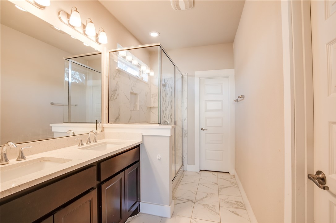 9707 McKnight Loop Austin, TX 78717 - Photo 9 of 17 a bathroom with a double vanity sink and mirror