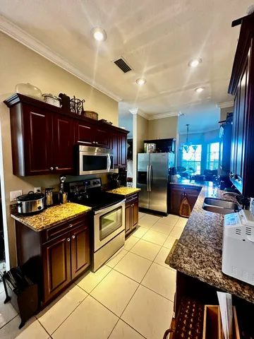 a kitchen with stainless steel appliances granite countertop a stove a sink and a microwave