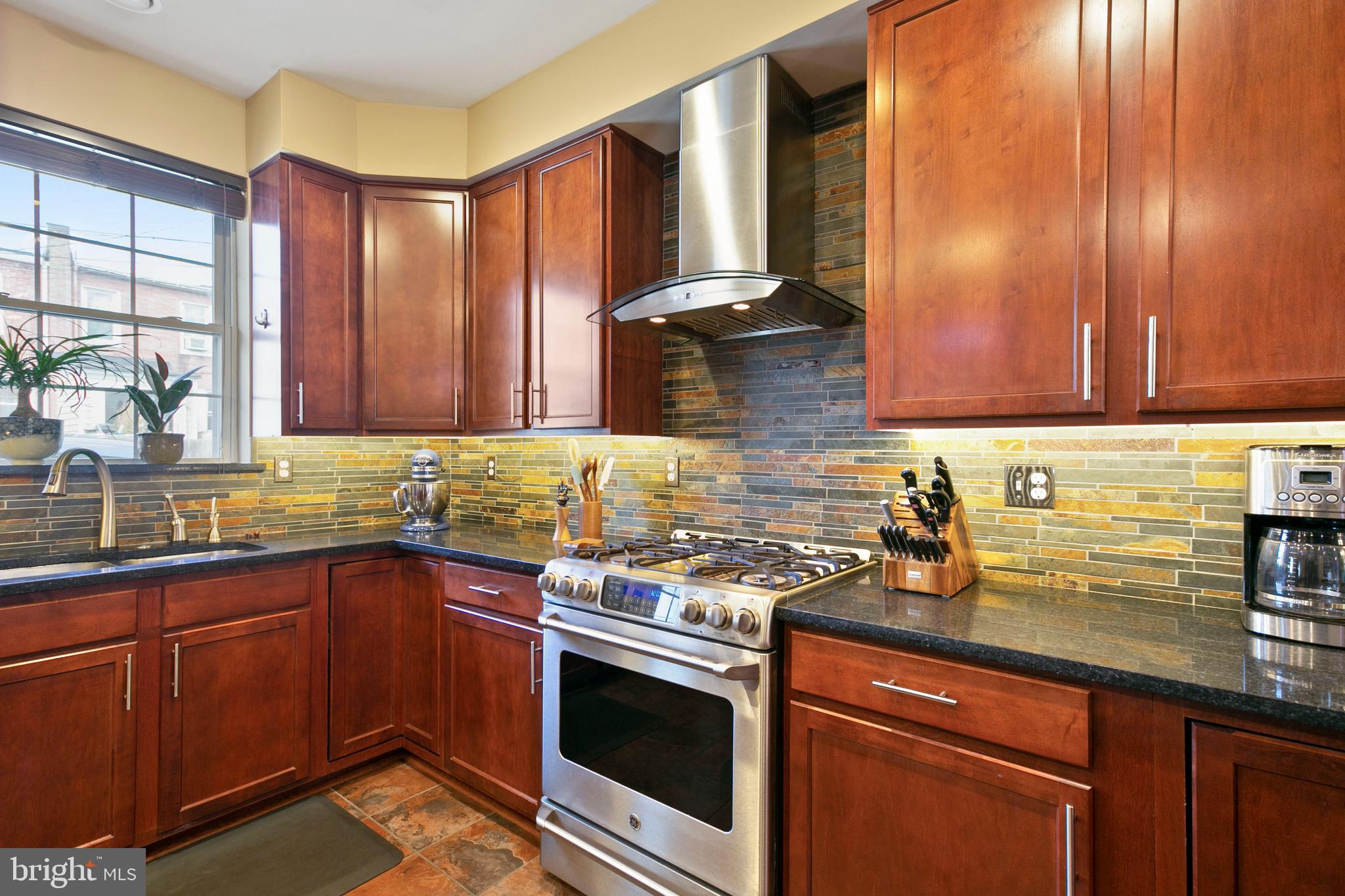 1230 Cooksie Street Baltimore, MD 21230 - Photo 12 of 41 a kitchen with a sink a stove cabinets and wooden floor