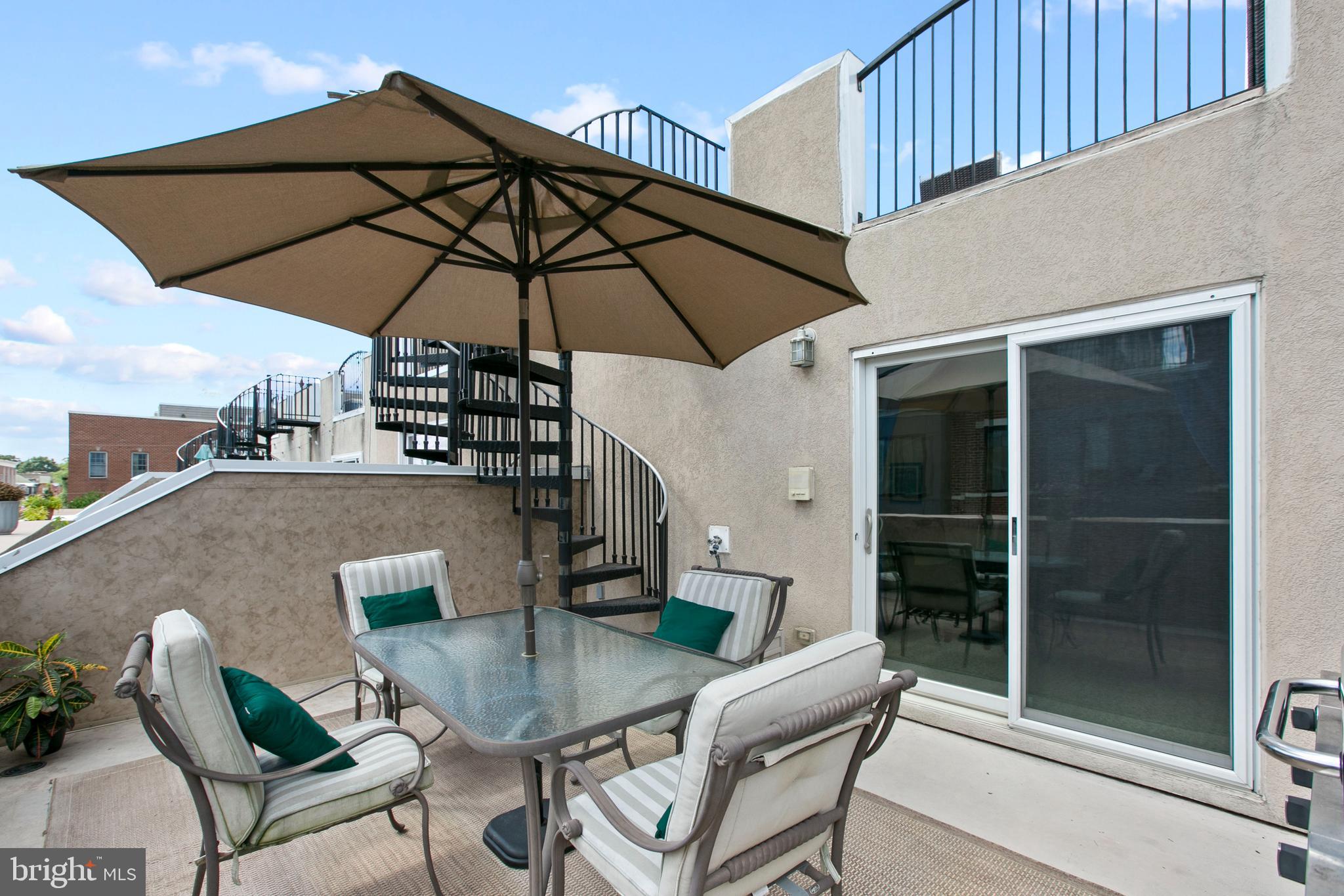 1230 Cooksie Street Baltimore, MD 21230 - Photo 35 of 41 a patio with a table and chairs under an umbrella