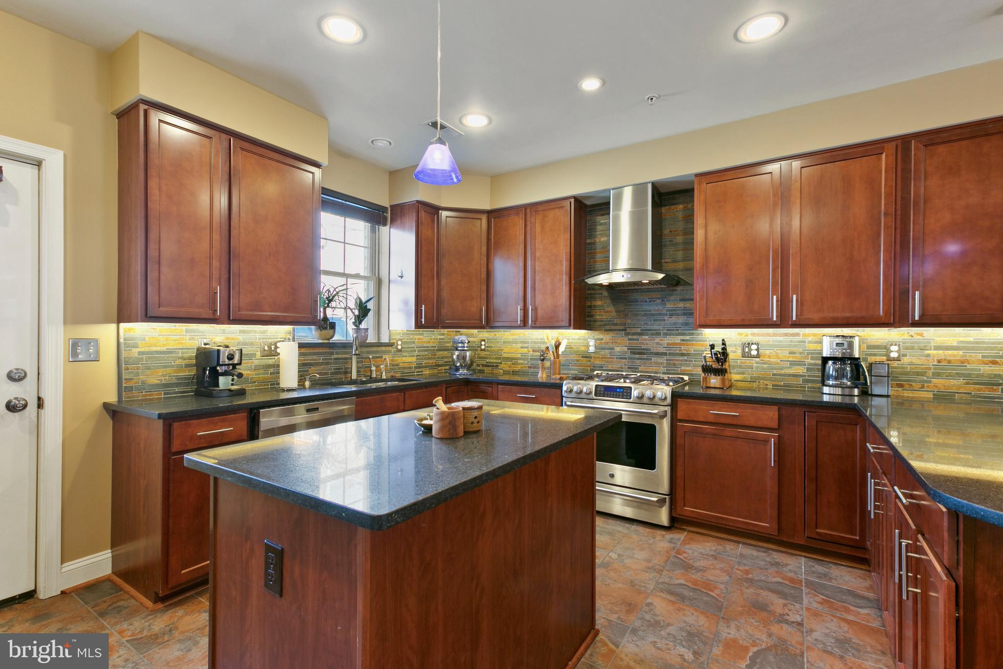 1230 Cooksie Street Baltimore, MD 21230 - Photo 10 of 41 a kitchen with kitchen island granite countertop wooden cabinets stainless steel appliances a sink and a counter top space