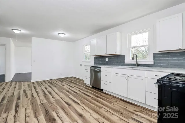 a kitchen with granite countertop a sink cabinets and stainless steel appliances